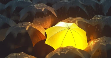 Ein einzelner gelber Regenschirm leuchtet inmitten vieler dunkler, regennasser Regenschirme hervor.