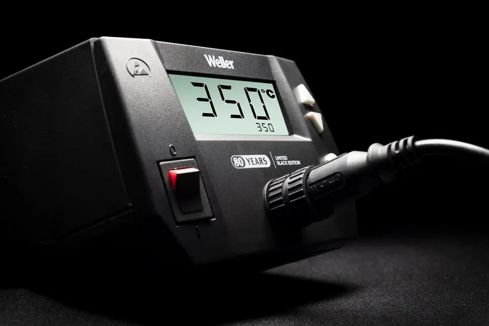 A Weller WE1010 Limited Black Edition soldering station marking the brand’s 80th anniversary, shown in a dark setting. The display reads 350 °C, with a connected soldering iron. The front panel features a red power switch and a special edition badge.