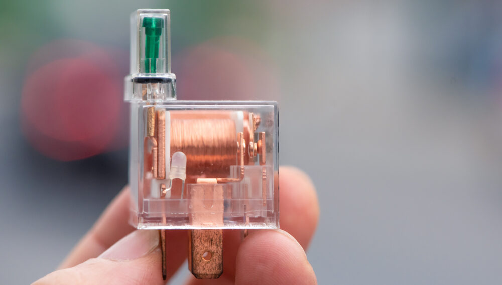 Automotive transparent relay with fuse on road background