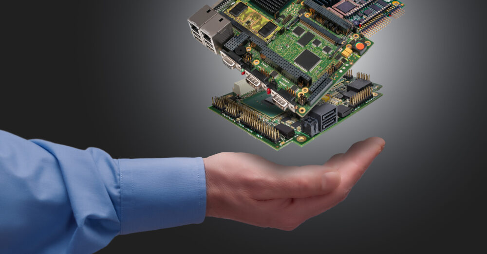 Schwebende industrielle Embedded-CPU-Platinen über einer Hand vor grauem Hintergrund