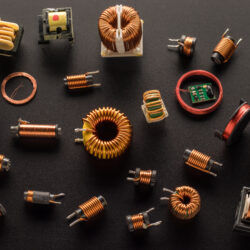 Inductors with a ferrite core, inductor copper coil, and also round RFID Antenna copper coil on a black background, top view